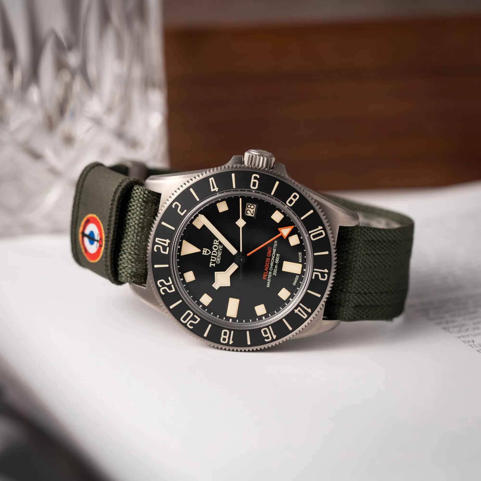 Produktfotografie der Tudor Pelagos GMT Military der Referenz M2542G257NU-0002 mit Titan-Gehäuse und schwarzem Zifferblatt an einem olivgrünen Nato-Strap