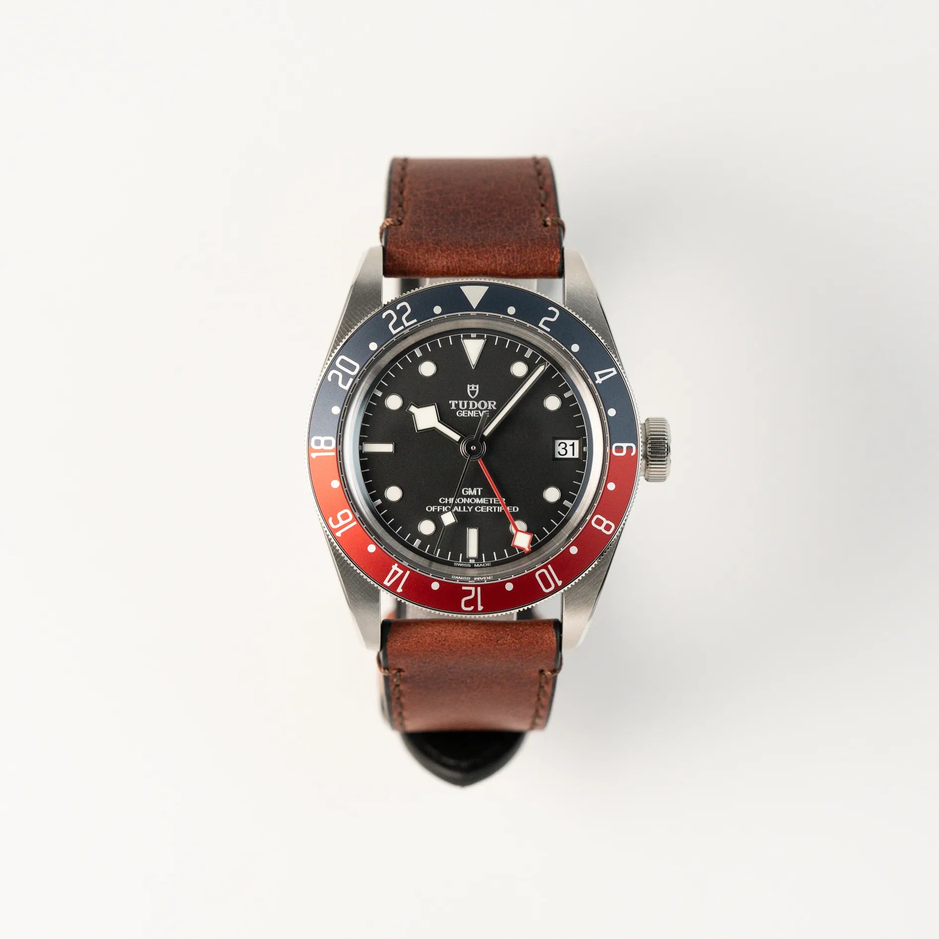 Frontale Ansicht der Tudor Black Bay Pepsi mit der Referenz 97830RB am braunen Lederband im Neuzustand