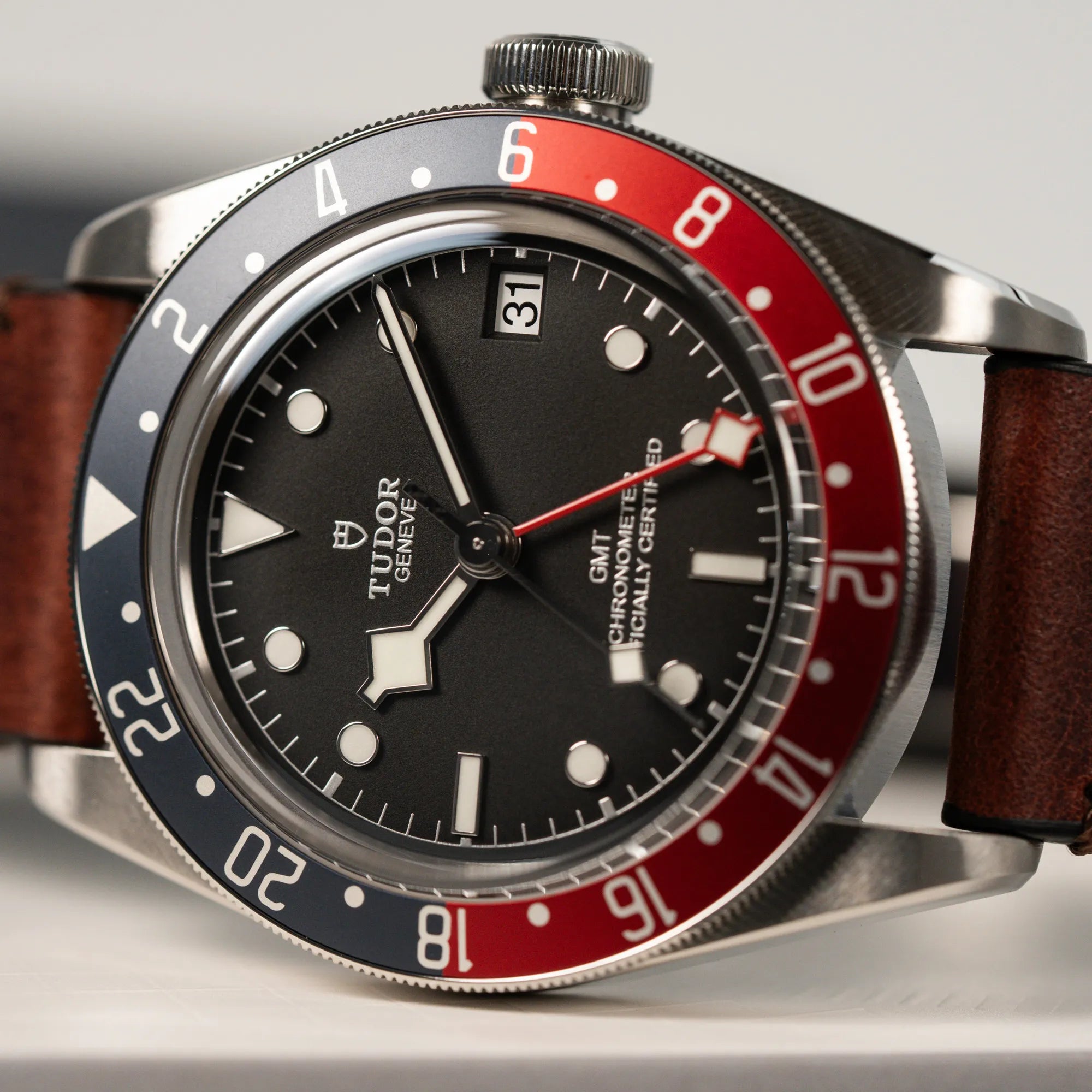 Detailaufnahme der Tudor Black Bay Pepsi mit der Referenz 97830RB am braunen Lederband im Neuzustand