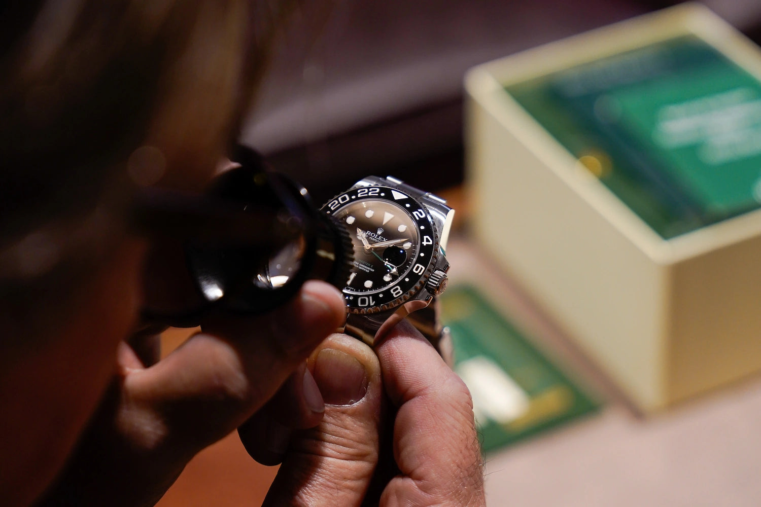 Begutachten einer Rolex GMT Master mit schwarzer Lünette für den Ankauf der Luxusuhr