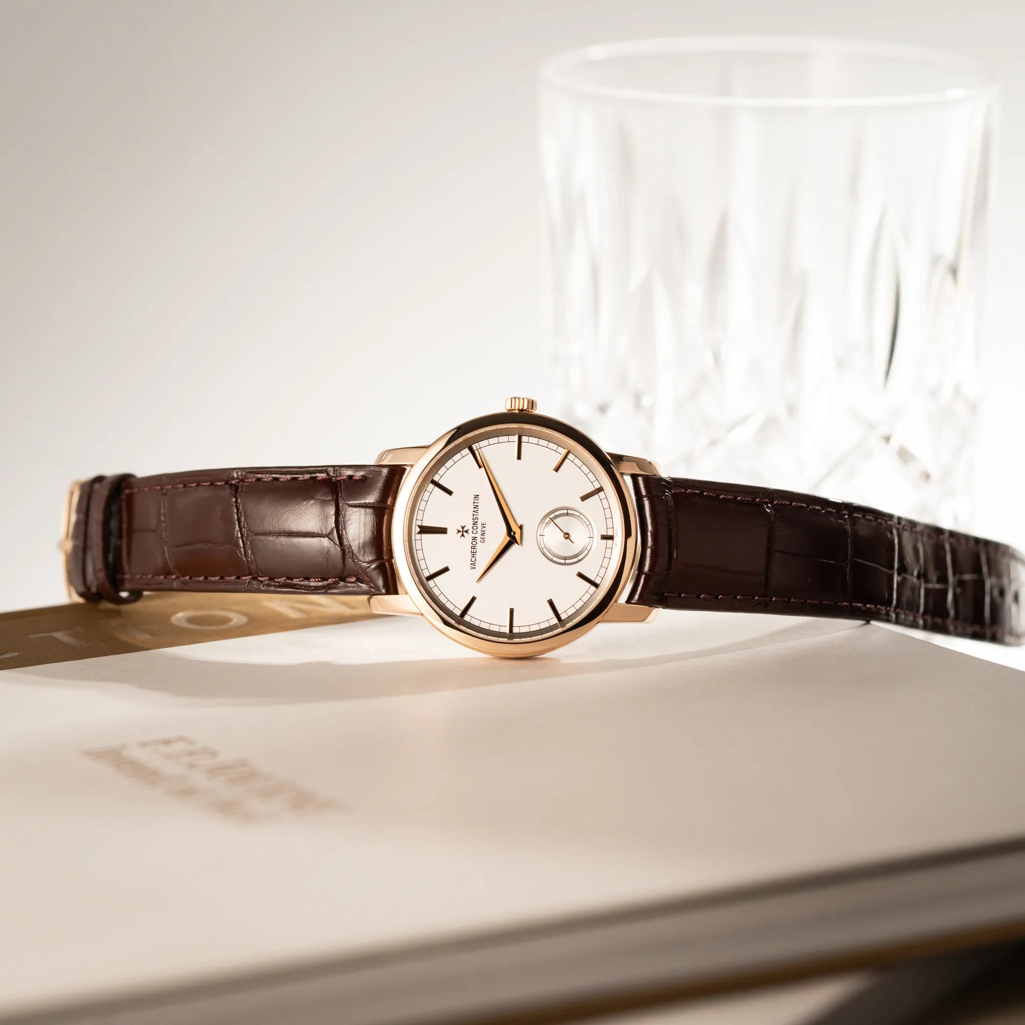 Produktfotografie der seitlich auf dem Uhrengehäuse liegenden Vacheron Constantin Patrimony 82172 in Roségold am braunem Lederband in einem nahezu neuwertigen Zustand