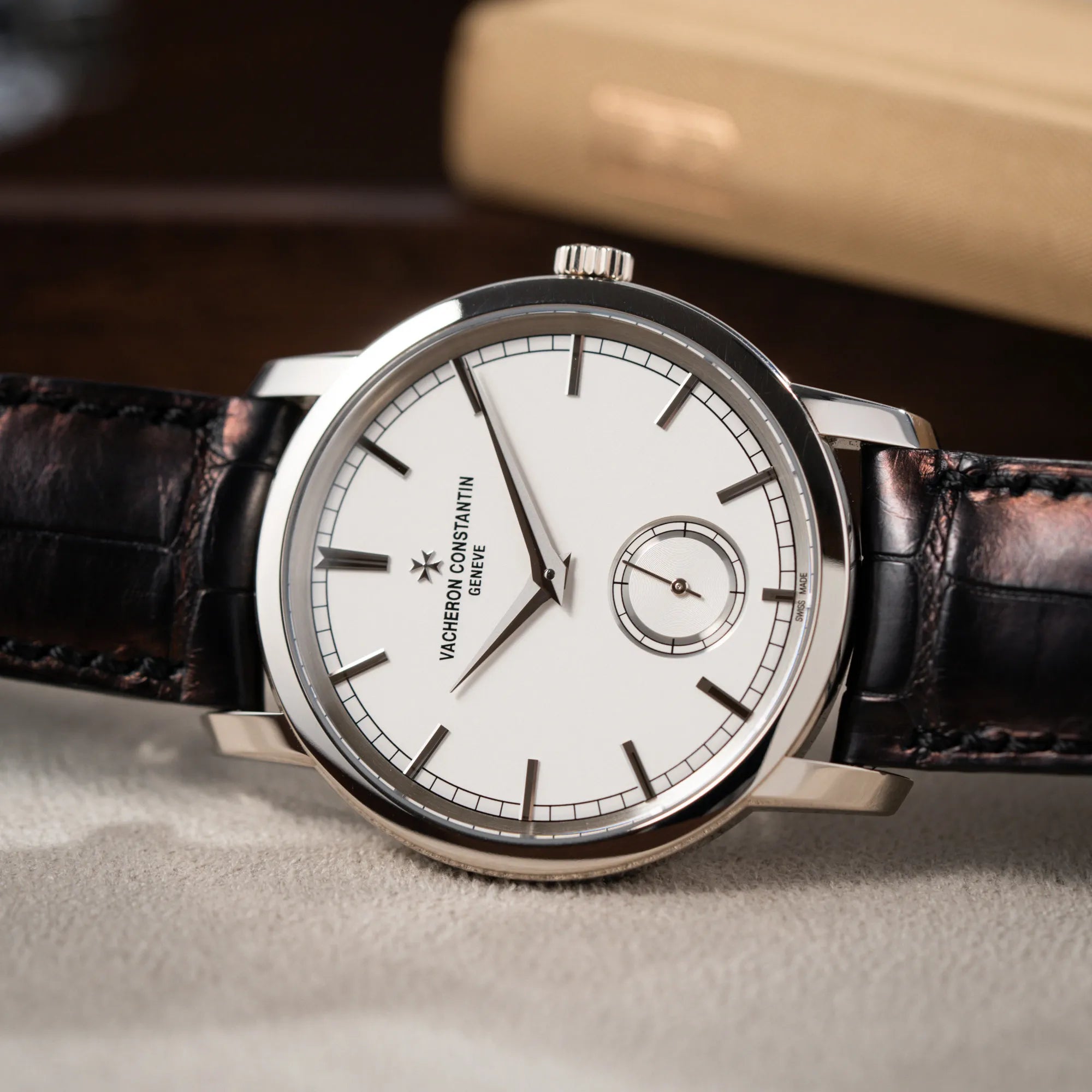 Detailaufnahme der seitlich auf dem Uhrengehäuse liegenden Vacheron Constantin Traditionelle 82172 mit weißem Zifferblatt und einem Weißgold-Gehäuse am braunem Lederband