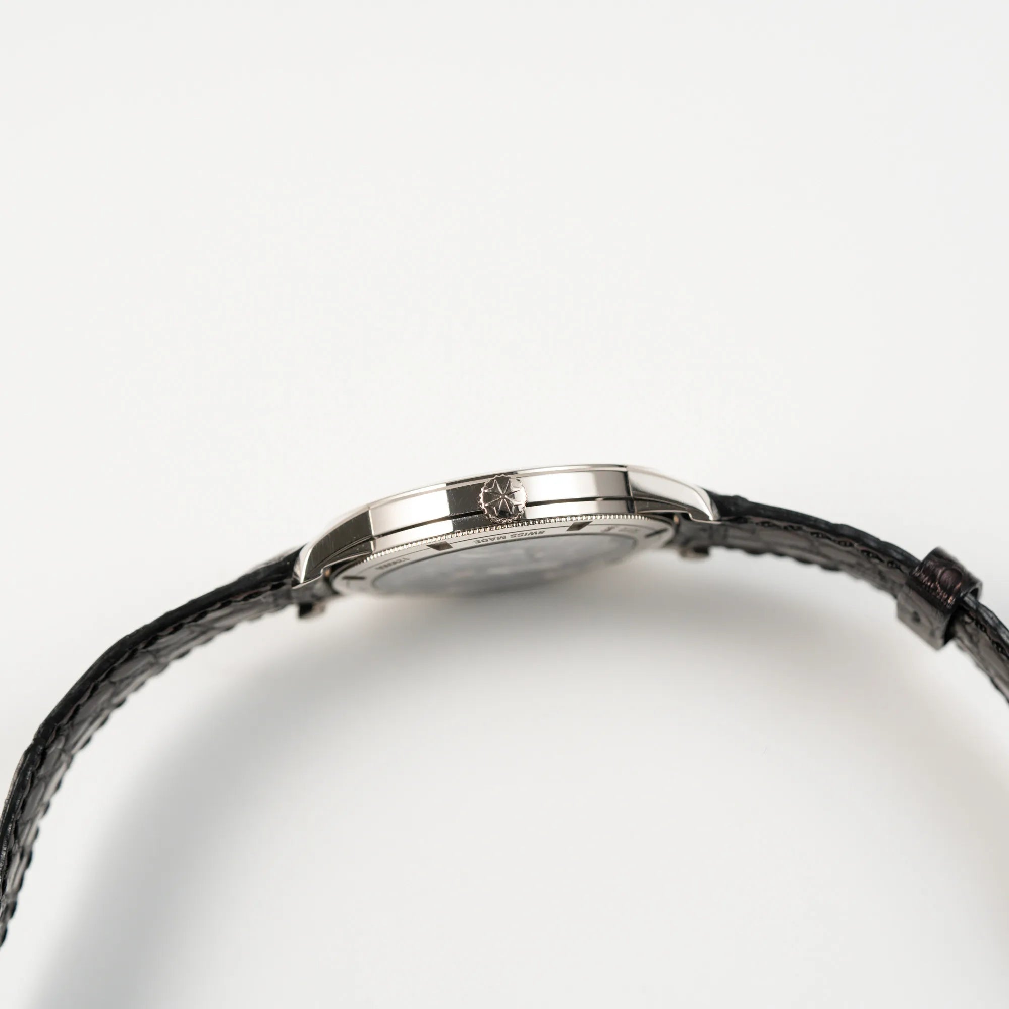 Seitliche Gehäuseflanke der Vacheron Constantin Traditionelle 82172 mit weißem Zifferblatt und einem Weißgold-Gehäuse am braunem Lederband mit Blcik auf die Aufzugskrone