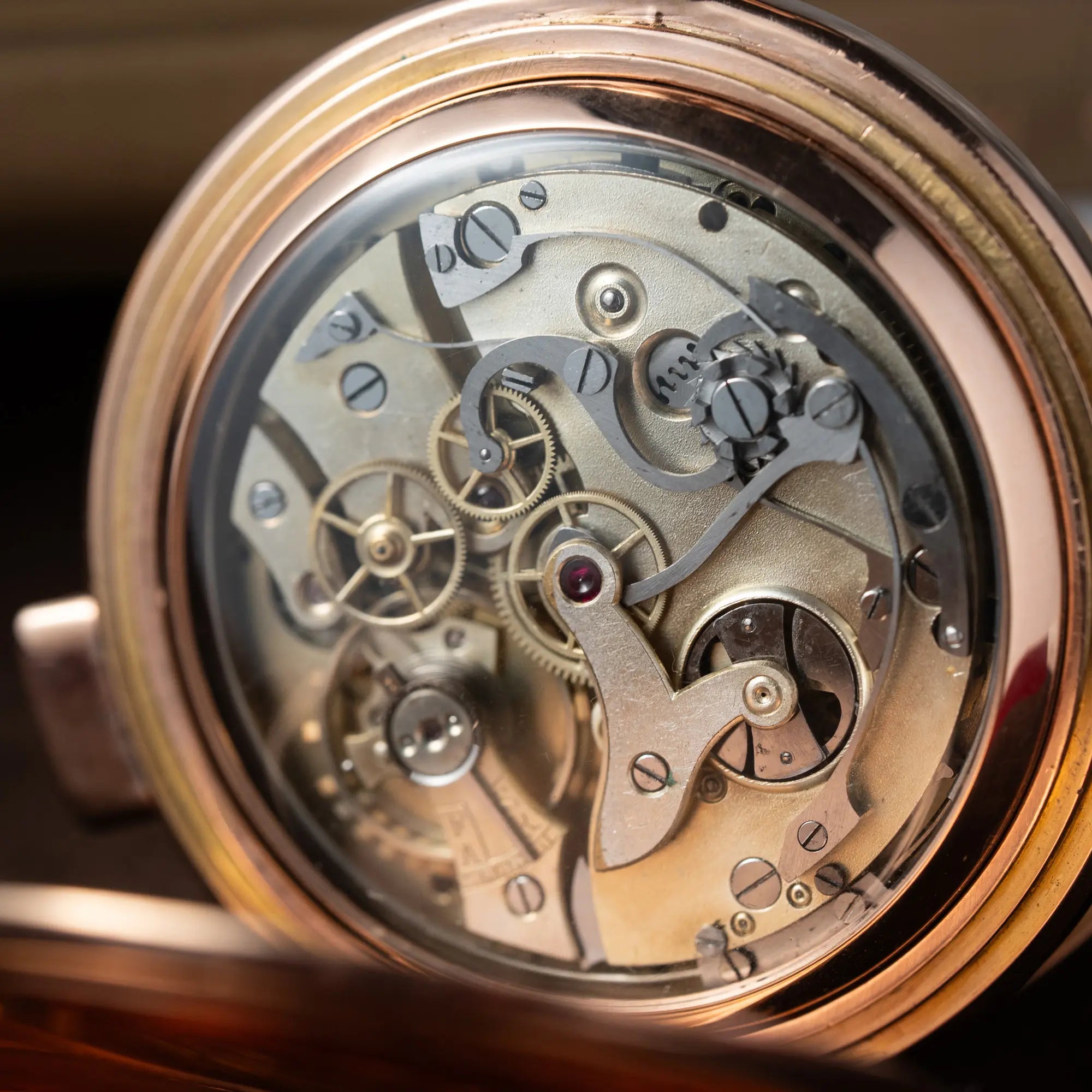 Blick auf das Uhrwerk der Vollkalender Taschenuhr aus 14 Karat Roségold mit viertel Stunden Repetition und Mondphase-Anzeige bei 6 Uhr