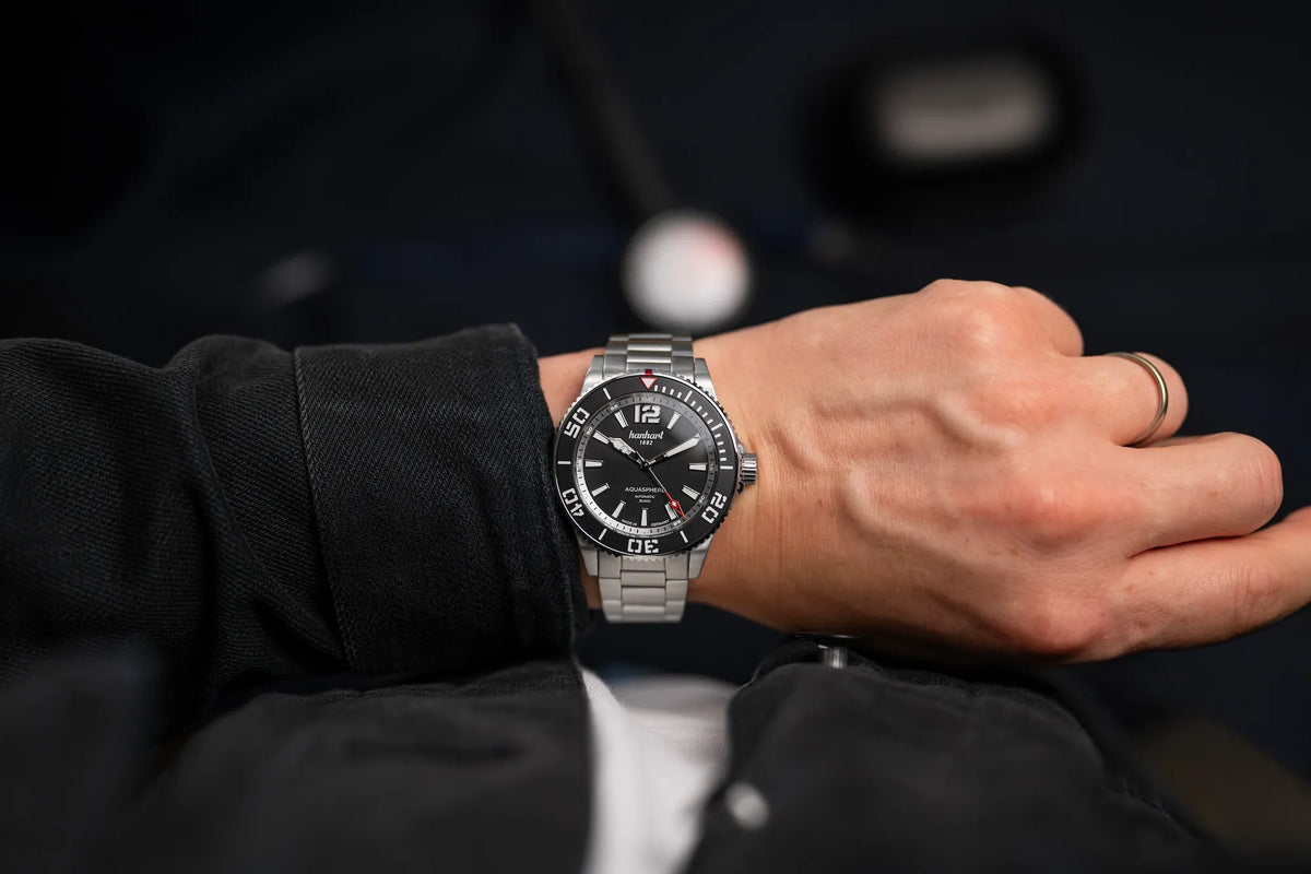 Mann trägt die Hanhart Aquasphere Matte Black im 42mm-Edelstahl-Gehäuse am Edelstahlarmband mit schwarzem Zifferblatt und schwarzer Lünette an seinem Handgelenk